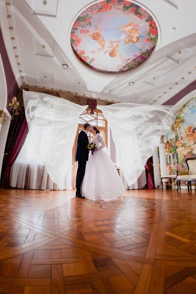 Hochzeitspaar und Vorhänge fliegen in die Luft — Stockfoto