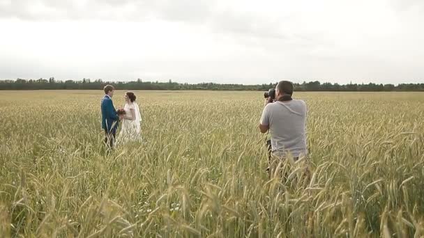 Фотограф фотографирует пару молодоженов — стоковое видео