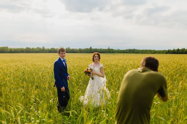 Photographe prenant des photos couple de jeunes mariés — Photo