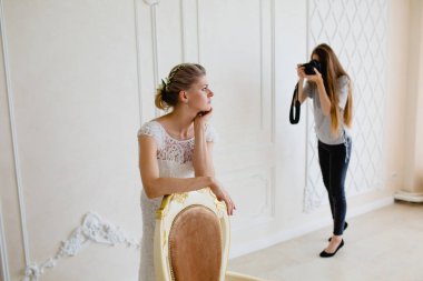 Sandalye yakınındaki Studio'da genç seksi gelin fotoğraf çekimi fotoğrafçı