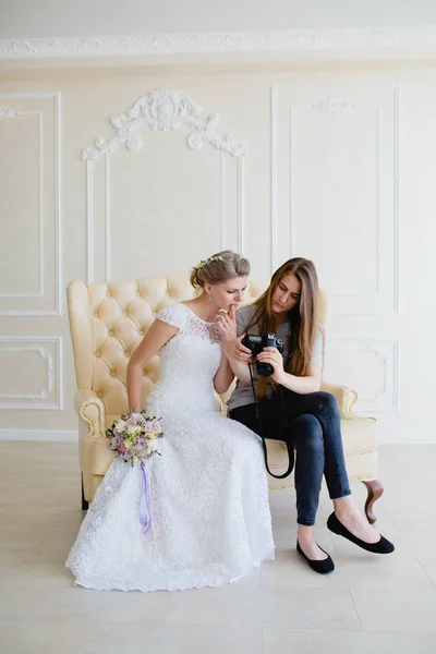 Fotograf zeigt junge sexy Braut, die gerade Fotos gemacht hat — Stockfoto