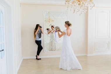 Ayna yakınındaki Studio'da genç seksi gelin fotoğraf çekmeye fotoğrafçı