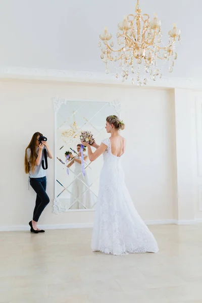 Fotograf fotografiert die junge sexy Braut im Studio neben dem Spiegel — Stockfoto