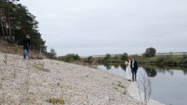 Fotograf i nowożeńcy w pobliżu rzeki — Wideo stockowe