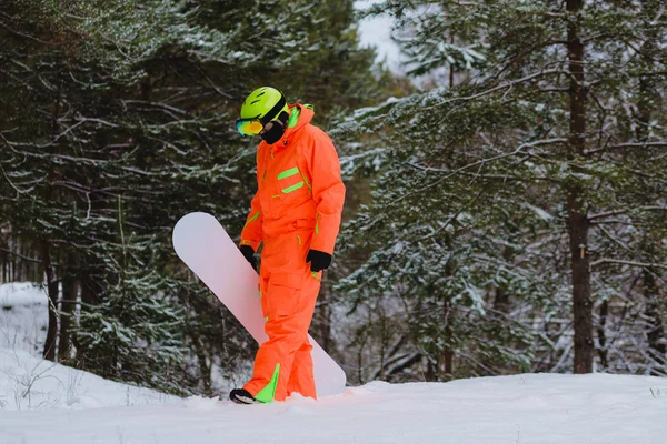 Snowboarder walking through the forest