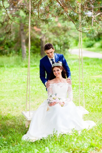 Beautiful couple newlyweds with the rope swing — Stock Photo, Image