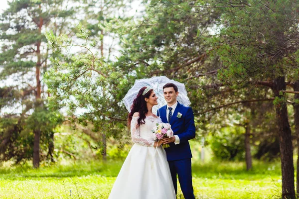 Beau couple de jeunes mariés avec le parapluie blanc — Photo