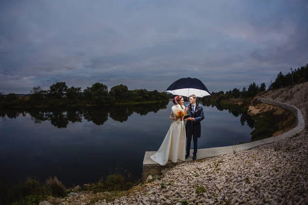 Couple jeunes mariés avec grand parapluie — Photo