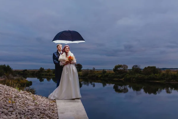 Couple jeunes mariés avec grand parapluie — Photo