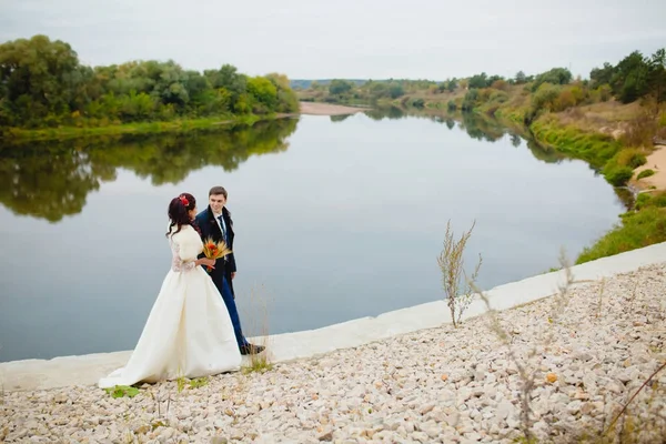 Beau couple jeunes mariés près de la rivière — Photo