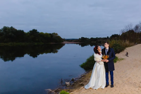 Beau couple jeunes mariés près de la rivière — Photo