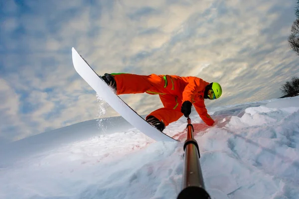 Snowboarder doen een truc en het maken van een selfie — Stockfoto