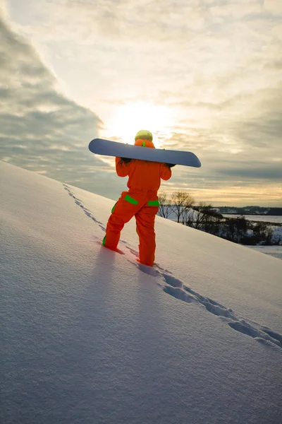 Snowboarder hegymászás tetején sípálya — Stock Fotó