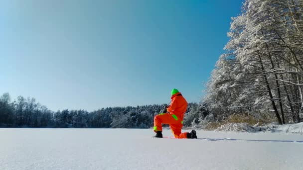 Fotograf macht ein Foto auf der Oberfläche des zugefrorenen Sees — Stockvideo