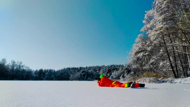Fotograf liegt auf einer Oberfläche des zugefrorenen Sees — Stockvideo