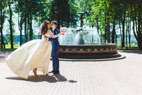 Beau couple jeunes mariés près de la fontaine — Photo