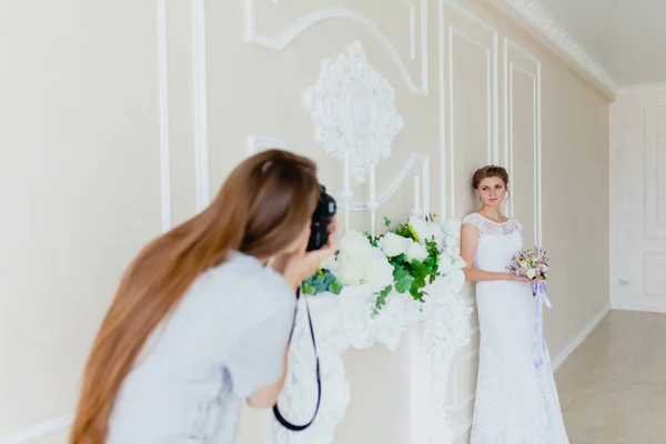 Fotograf mit langen Haaren fotografiert die junge sexy Braut — Stockfoto
