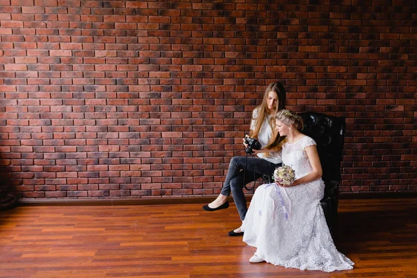 Fotografer menunjukkan pengantin baru saja mengambil foto di atas kursi kulit besar — Stok Foto