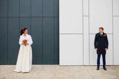 Güzel çift yeni evliler gri duvarının yakınında