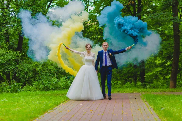Mariée et marié avec des bombes fumigènes colorées — Photo