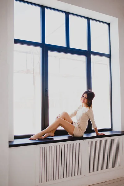 Tall slender brunette near the window — Stock Image Tall slender brunette near the window Royalty Free Stock Photos