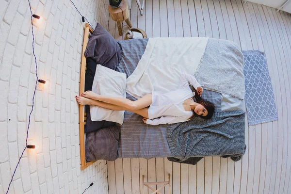 Sexy slender brunette lying on a big bed — Stock Image Sexy slender brunette lying on a big bed Stock Picture