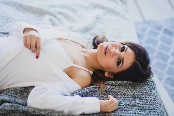Sexy slender brunette lying on a big bed — Stock Image Sexy slender brunette lying on a big bed Stock Picture