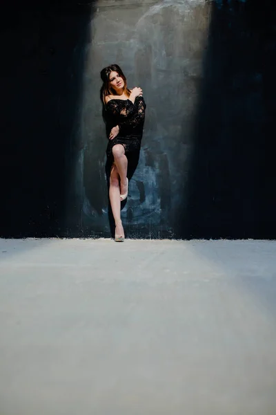 Brunette posing near black wall in the studio — Stock Image Brunette posing near black wall in the studio Stock Photo