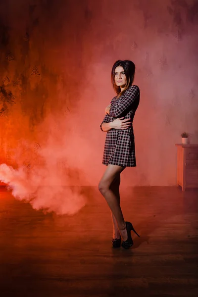 Brunette posing in a cloud of orange smoke — Stock Image Brunette posing in a cloud of orange smoke Royalty Free Stock Images