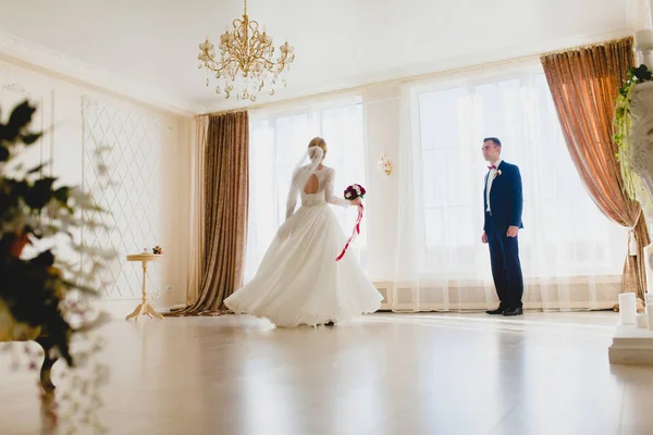 Bräutigam beobachtet, wie seine Braut am großen Fenster tanzt — Stockfoto