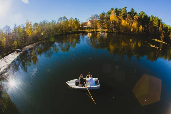 Όμορφο νεαρό ζευγάρι σε ένα μικρό σκάφος που πλέει σε μια λίμνη — Φωτογραφία Αρχείου