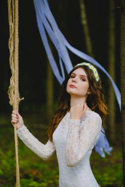 Güzel genç gelin salıncağın yanında poz veriyor