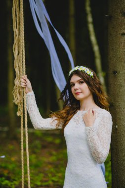 Güzel genç gelin salıncağın yanında poz veriyor