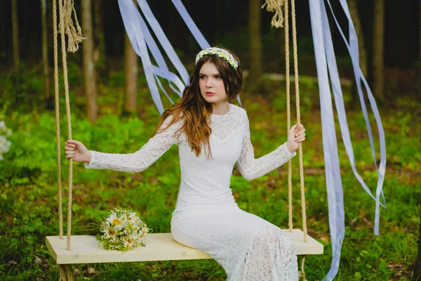 Retrato de la hermosa novia joven sentada en el columpio de cuerda — Foto de Stock