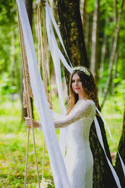 Bella giovane sposa in posa vicino all'altalena corda — Foto Stock