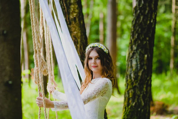 Hermosa joven novia posando cerca del columpio de cuerda — Foto de Stock