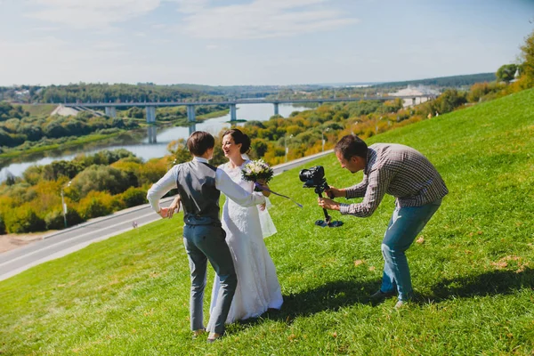 Photographe de mariage prenant des photos de la mariée et le marié sur une colline — Photo