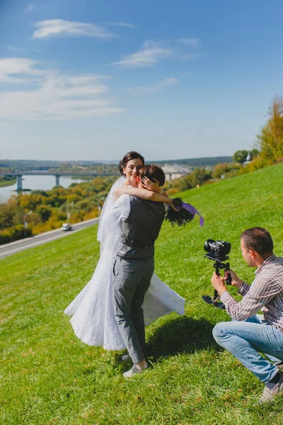 Photographe de mariage prenant des photos de la mariée et le marié sur une colline — Photo