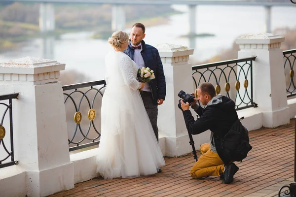 Fotógrafo de casamento tirando fotos da noiva e noivo no beco do parque — Fotografia de Stock