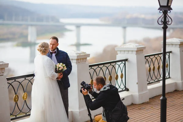 Fotógrafo de casamento tirando fotos da noiva e noivo no beco do parque — Fotografia de Stock