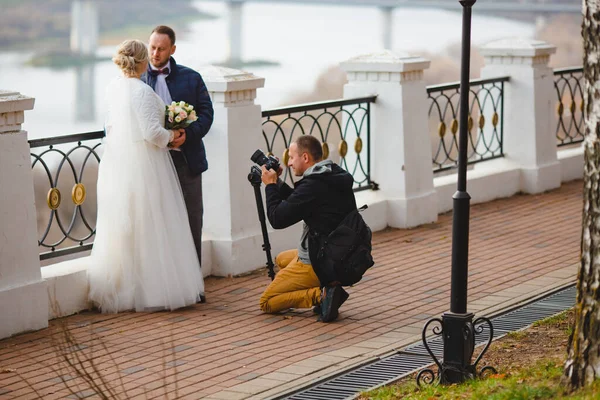 Photographe de mariage prenant des photos de la mariée et le marié sur l'allée du parc — Photo