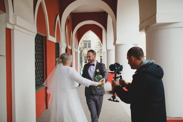 Fotógrafo de casamento tirando fotos da noiva e do noivo em uma galeria — Fotografia de Stock