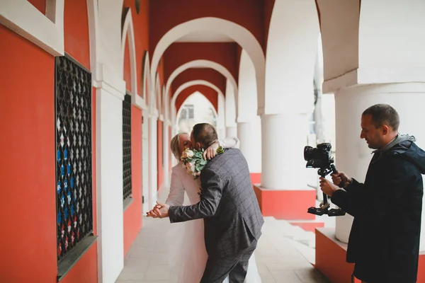 Fotógrafo de casamento tirando fotos da noiva e do noivo em uma galeria — Fotografia de Stock