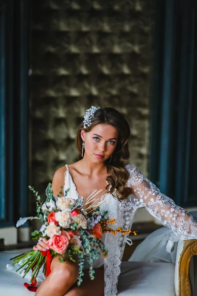 Крупним планом портрет молодої нареченої позує з розкішним весільним букетом на дивані — стокове фото