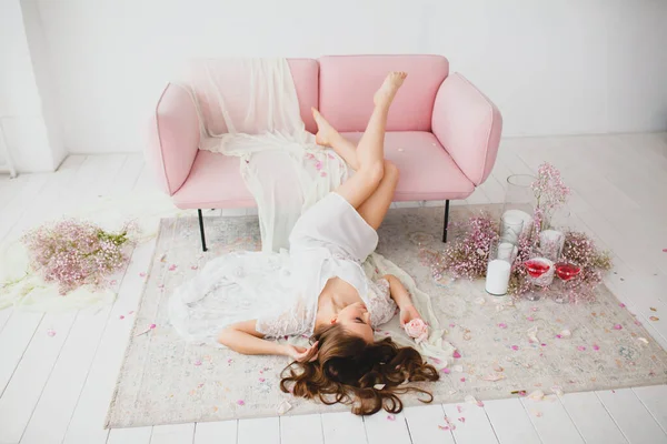Jonge bruid met mooie naakte benen poseren op een vloer in de grote witte studio — Stockfoto