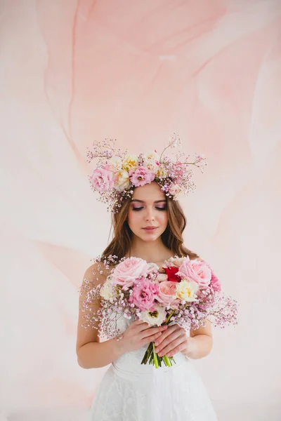 Retrato de novia hermosa con corona de flores en la cabeza y ramo de novia — Foto de Stock