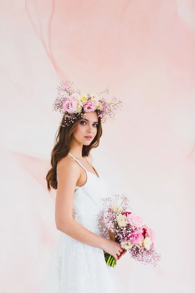 Ritratto di bella sposa con corona di fiori sulla testa e bouquet da sposa Immagini Stock Royalty Free