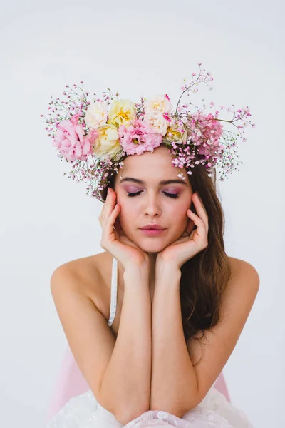Ritratto di bella sposa con corona di fiori sulla testa su sfondo bianco Foto Stock