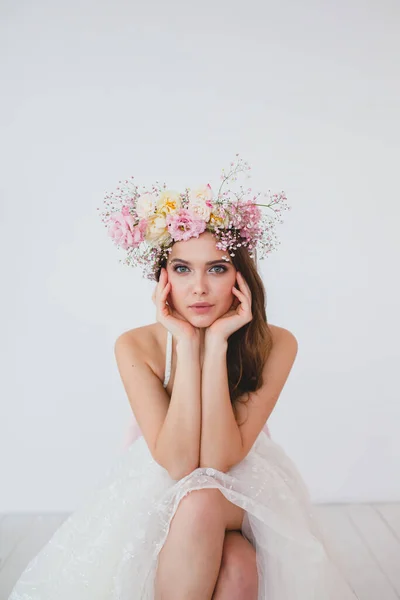 Retrato de novia hermosa con corona de flores en su cabeza en el fondo blanco — Foto de Stock