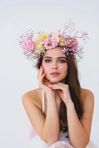 Retrato de novia hermosa con corona de flores en su cabeza en el fondo blanco — Foto de Stock